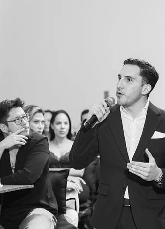 Alexis Abascal presentando con micrófono ante los asistentes del evento.